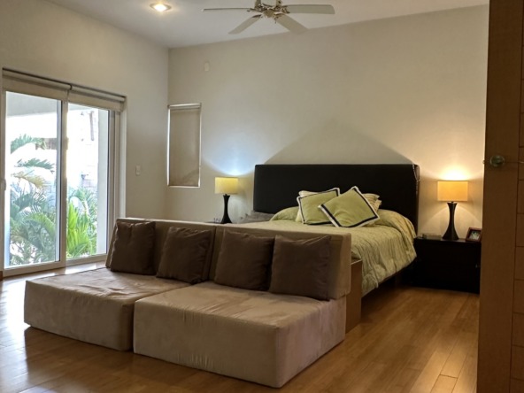 Casa en venta en lagos del sol cancun - Recámara luminosa con piso de madera y luces cálidas