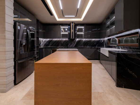 Casa en venta en puerto cancún - cocina con isla central,encimeras de mármol negro y una iluminación contemporánea en el techo